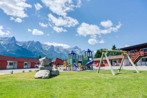 a park with a playground with mountains in the background at Rocky Mountain Ski Lodge in Canmore