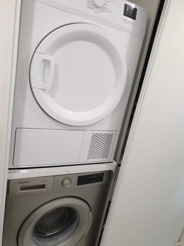 a washing machine with a mirror on top of it at Les Rochettes, joli appartement, tout neuf, calme et paisible in Saint-Gervais-dʼAuvergne