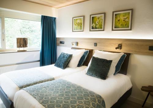 2 camas en una habitación de hotel con ventana en De Guldenberg 's-Hertogenbosch Helvoirt, en Helvoirt