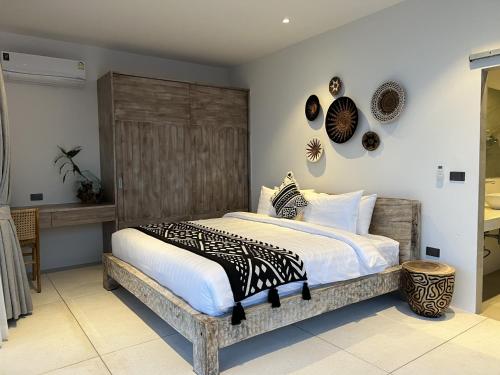 a bedroom with a large bed with a wooden headboard at AURA AIR 1, pool & seaview villa, Choengmon 500m in Koh Samui 