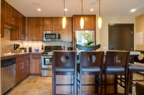 a kitchen with wooden cabinets and a island with bar stools at Silver Creek Lodge in Canmore