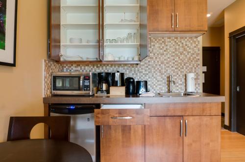 a kitchen with wooden cabinets and a microwave at Silver Creek Lodge in Canmore