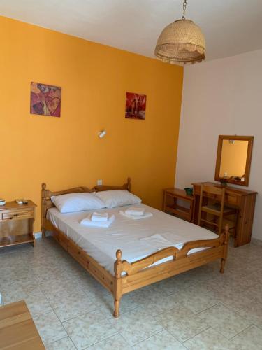 a bedroom with a bed and a yellow wall at Dafni Studios in Neo Klima