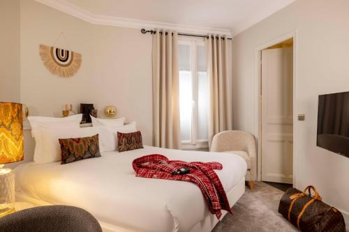 a hotel room with a bed with a red scarf on it at Hôtel de Banville in Paris