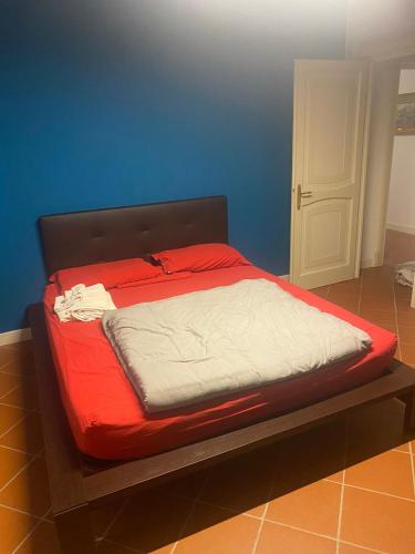 a bed in a room with a red and white mattress at Corte Storica in Cortemaggiore