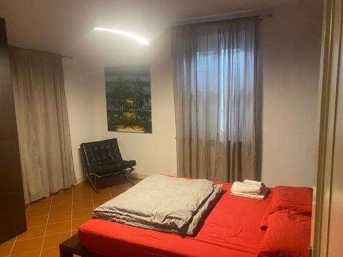 um quarto com uma cama, uma cadeira e uma janela em Corte Storica em Cortemaggiore