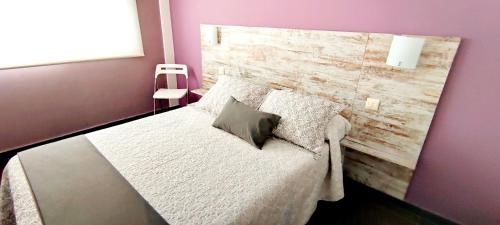 トッサ・デ・マールにあるApartament Marinaのベッドルーム1室(木製ヘッドボード付きのベッド1台付)