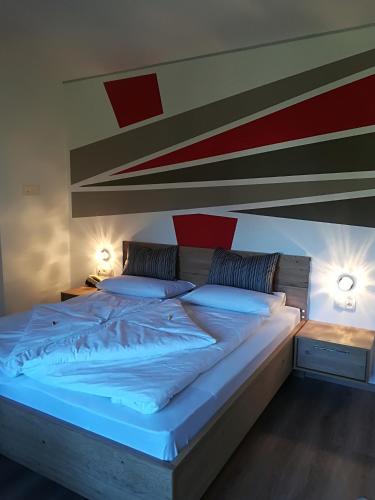 a large bed in a room with two lamps at Garni Brunnenhof in Caldaro