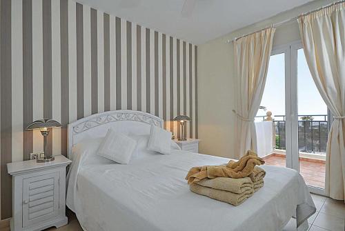 アデへにあるSunshine Villaのベッドルーム1室(白いベッド1台、タオル付)