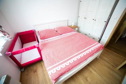 a bedroom with a bed with pink sheets and white cabinets at Domčeky Sabinka a Melinka in Valča