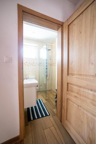 a bathroom with a sink and a glass shower at Domčeky Sabinka a Melinka in Valča