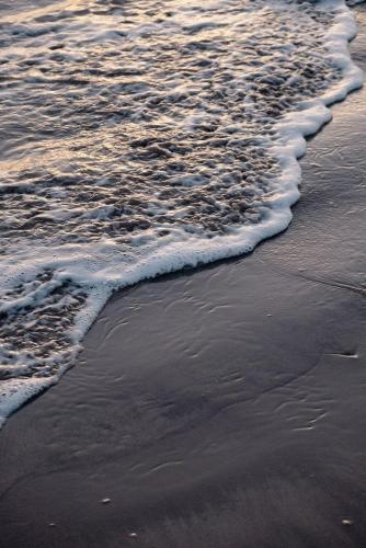 a close up of the shoreline of a beach at The Isla & Casita in Batemans Bay