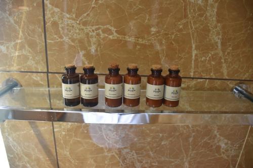 a row of bottles on a shelf on a wall at Jeevess Retreat Wayanad in Wayanad