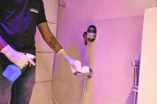 a man standing in a bathroom with a shower at Elite Homes in Aurangabad