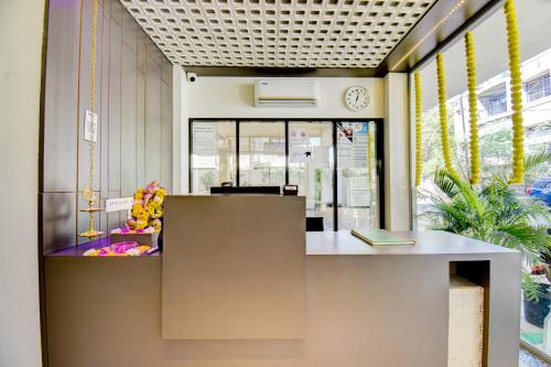 a lobby with a reception desk and a clock at Elite Homes in Aurangabad