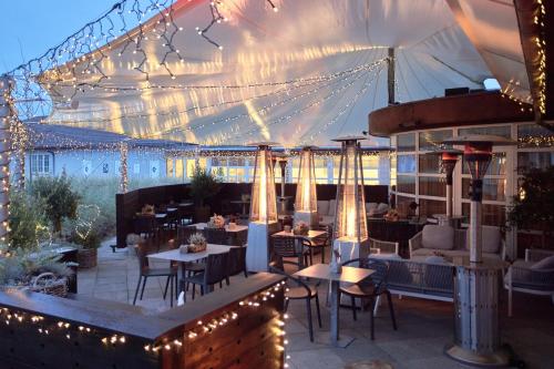 a restaurant with tables and chairs under a tent at Color Hotel Skagen in Skagen
