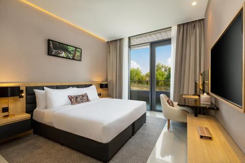 Millennium Place Mirdif Apartments في دبي: غرفه فندقيه سرير وتلفزيون