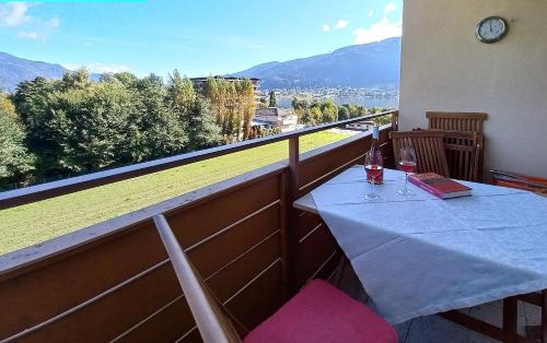 una mesa con 2 copas de vino en el balcón en ELISABETH Haus KMB Seeappartement direkt am Ossiacher See mit Hallenbad Skiarena Gerlitzen en Bodensdorf