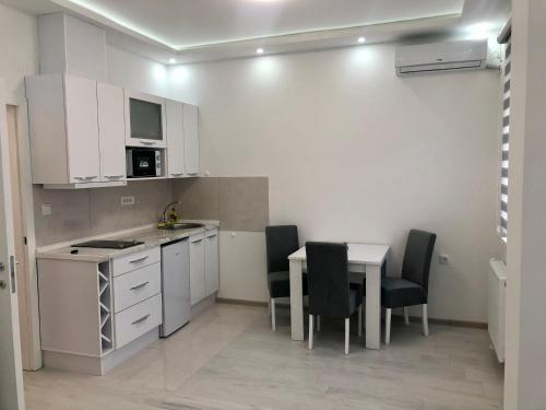 a kitchen with a table and chairs in a room at Apartman Silver Star in Sombor