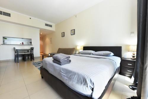a bedroom with a bed and a table and a chair at Studio in JLT X1 Tower close to Metro - DB in Dubai