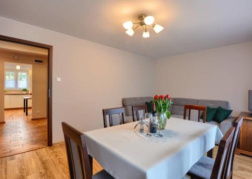 烏斯奇基的住宿－Apartament Zielony Zakątek，一间配备有白色桌椅的用餐室