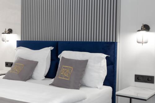 a bed with white pillows and a blue head board at Kayus in Buşteni