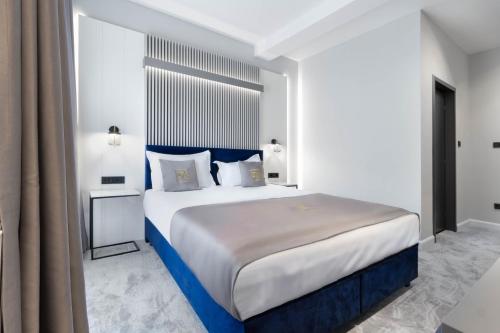a bedroom with a large bed with blue accents at Kayus in Buşteni