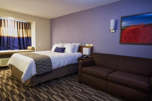 um quarto de hotel com uma cama e um sofá em Microtel Inn & Suites Sault Ste. Marie em Sault Ste. Marie