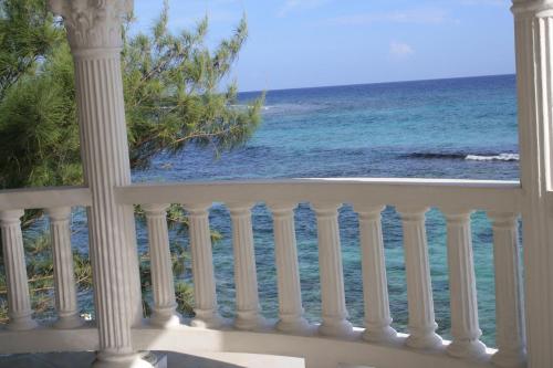 a balcony with a view of the beach at Triplets on the Bay in Montego Bay