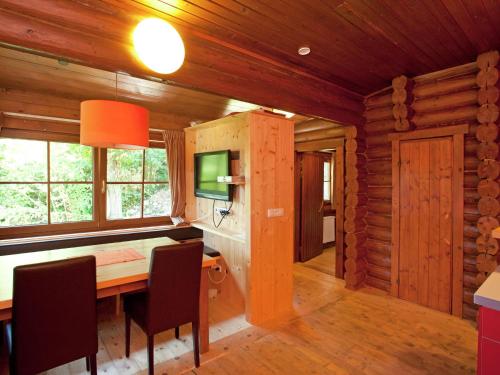 ein Esszimmer mit einem Tisch, Stühlen und einem TV in der Unterkunft Chalet in W rgl Boden in the Brixental in Salvenberg