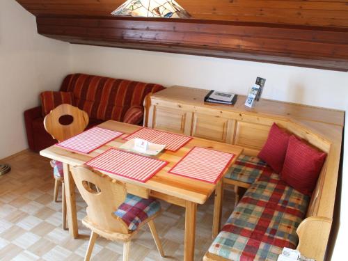 un tavolo da pranzo con 2 sedie e un divano di Holiday apartment in Nassfeld Carinthia with sauna a Sonnenalpe Nassfeld