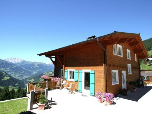 a house with a deck and mountains in the background at Lush Apartment in Silbertal with Garden in Silbertal