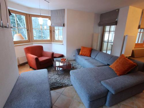 a living room with a blue couch and chairs at Lovely Chalet with Sauna Ski Storage Heating Carport in Saalbach Hinterglemm