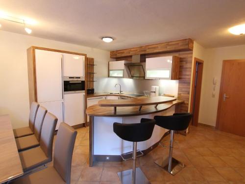 a kitchen with a kitchen island with chairs in it at Lovely Chalet with Sauna Ski Storage Heating Carport in Saalbach Hinterglemm