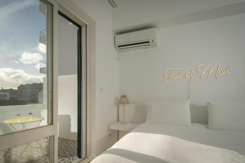 een slaapkamer met 2 bedden en een raam met een wastafel bij TOI ET MOI DOWNTOWN-Guests speek for us! in Ponta Delgada