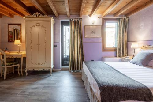 um quarto com uma cama, uma secretária e uma janela em Ca' Fontanea em Veneza