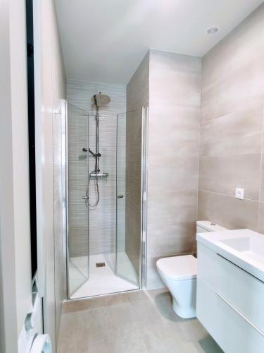 a bathroom with a shower and a toilet and a sink at VivaBien Playa I - Apartamentos junto al mar in Benicàssim