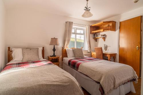 dwa łóżka w pokoju z oknem w obiekcie The Moorcock Inn w mieście Littleborough
