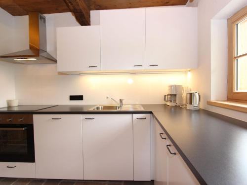 a kitchen with white cabinets and a sink at Chalet on the ski slope in St Johann in Tyrol in Apfeldorf