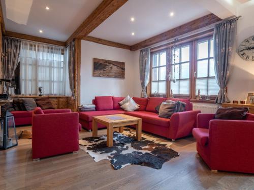 una sala de estar con sofás rojos y una mesa. en Luxurious Apartment in F rth with Pool en Piesendorf
