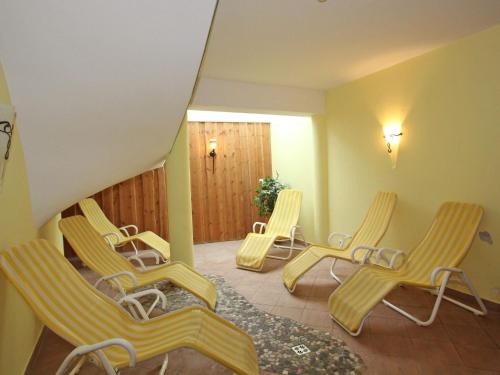 grupa żółtych krzeseł w pokoju w obiekcie Quaint Apartment in L ngenfeld with Sauna w mieście Huben