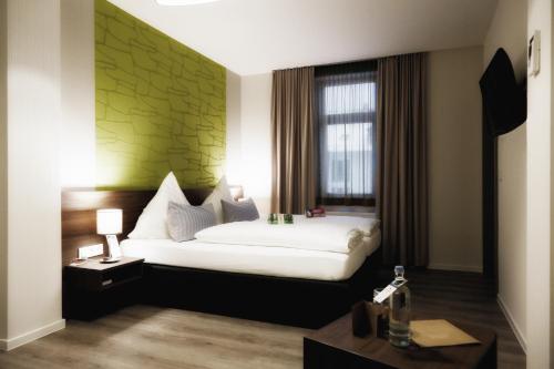 奧伯霍夫的住宿－Konsumhotel am Park - Nebenhaus Berghotel Oberhof - nur Übernachtung，一间卧室配有一张白色的床和绿色的墙壁