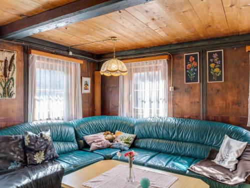 Holiday house in East Tyrol near ski area في ماتري إن أوستيرول: غرفة معيشة مع أريكة خضراء وطاولة