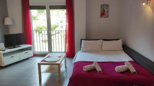 1 dormitorio con 1 cama con cortinas rojas y TV en SUITEDREAMS - Feixa 41 en Andorra la Vella