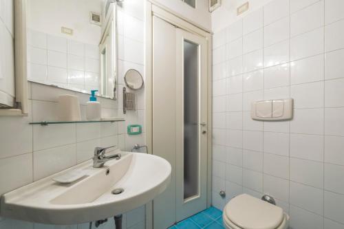 a white bathroom with a sink and a toilet at Porta Romana & Bocconi Cosy Apartment in Milan