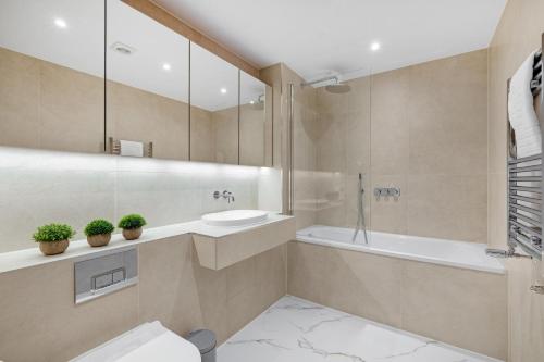 a bathroom with a tub and a sink and a shower at 2 Bedroom Luxury Apartments with Parking in Stanmore, North West By 360 Stays London in Stanmore