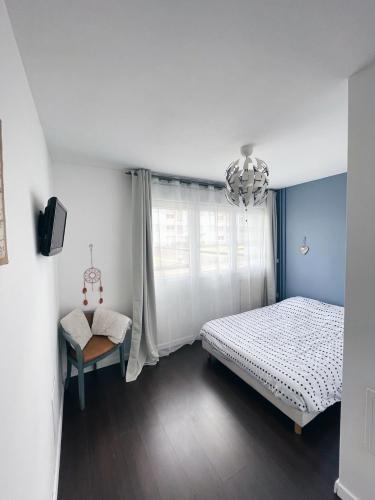 une chambre avec un lit, une chaise et une fenêtre dans l'établissement NEW: appartement tout confort + parking gratuit, à Amiens