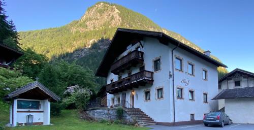 un grande edificio bianco con una montagna sullo sfondo di Haus Fiegl a Oetz