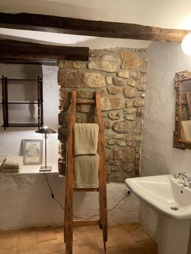 Łazienka z kamienną ścianą i umywalką w obiekcie La Casa del Bosque w mieście Cabra de Mora