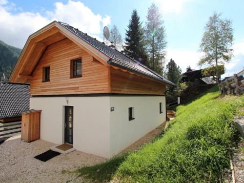 ein Haus mit einer weißen Garage und einem Holzdach in der Unterkunft Chalet in Bad Kleinkirchheim with sauna in Bad Kleinkirchheim